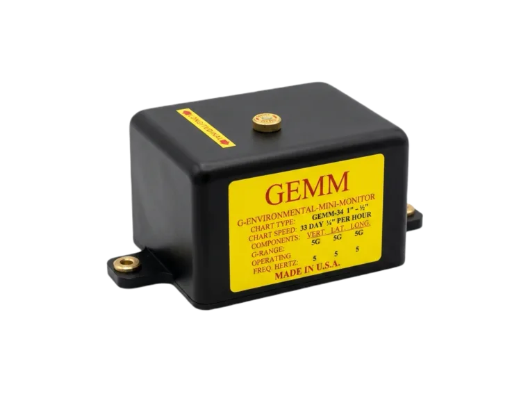 The GEMM multi-axis mini-monitor: a compact black enclosure with mounting flanges and a yellow specification label listing chart speed and G-range