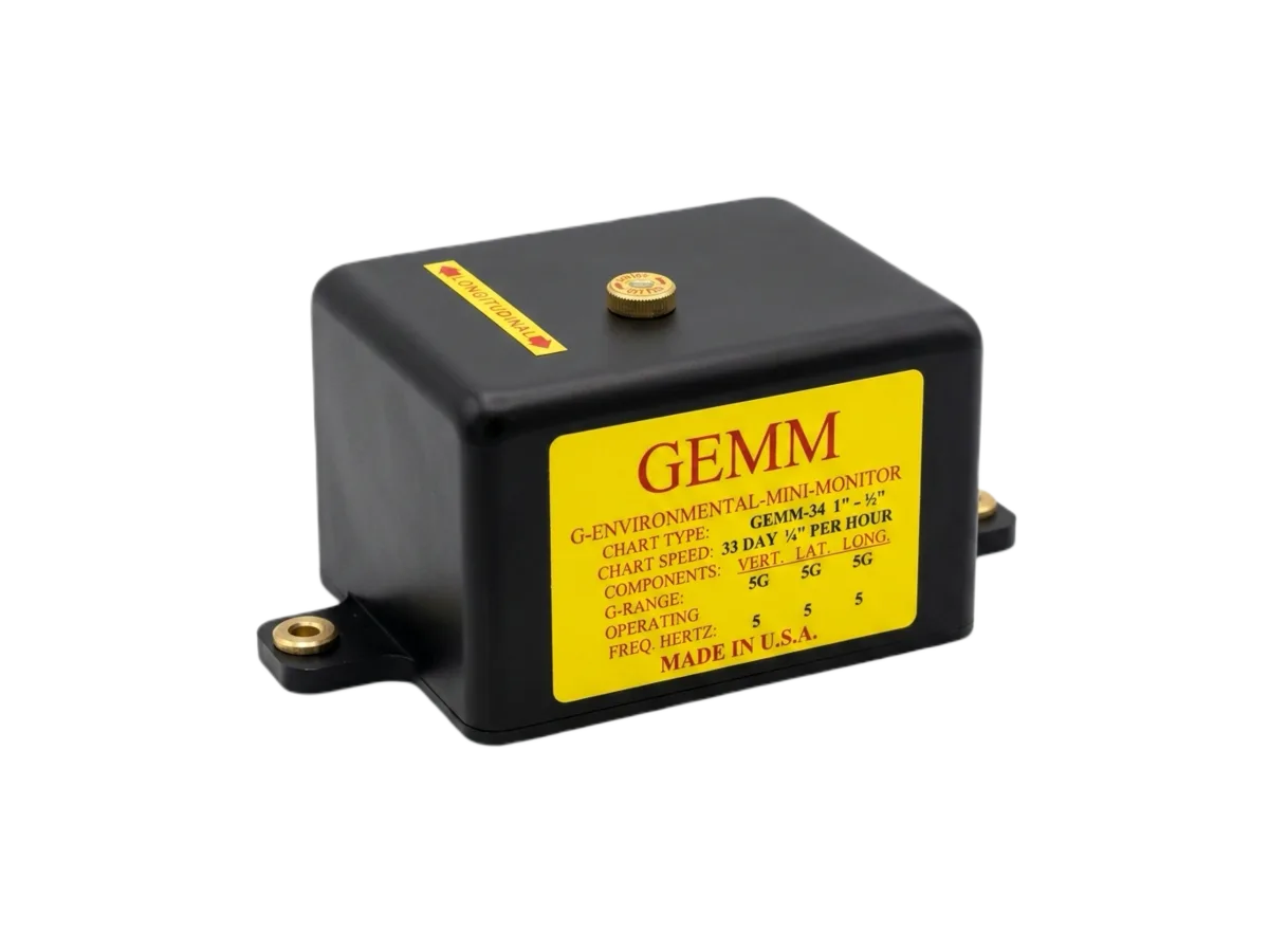 The GEMM multi-axis mini-monitor: a compact black enclosure with mounting flanges and a yellow specification label listing chart speed and G-range