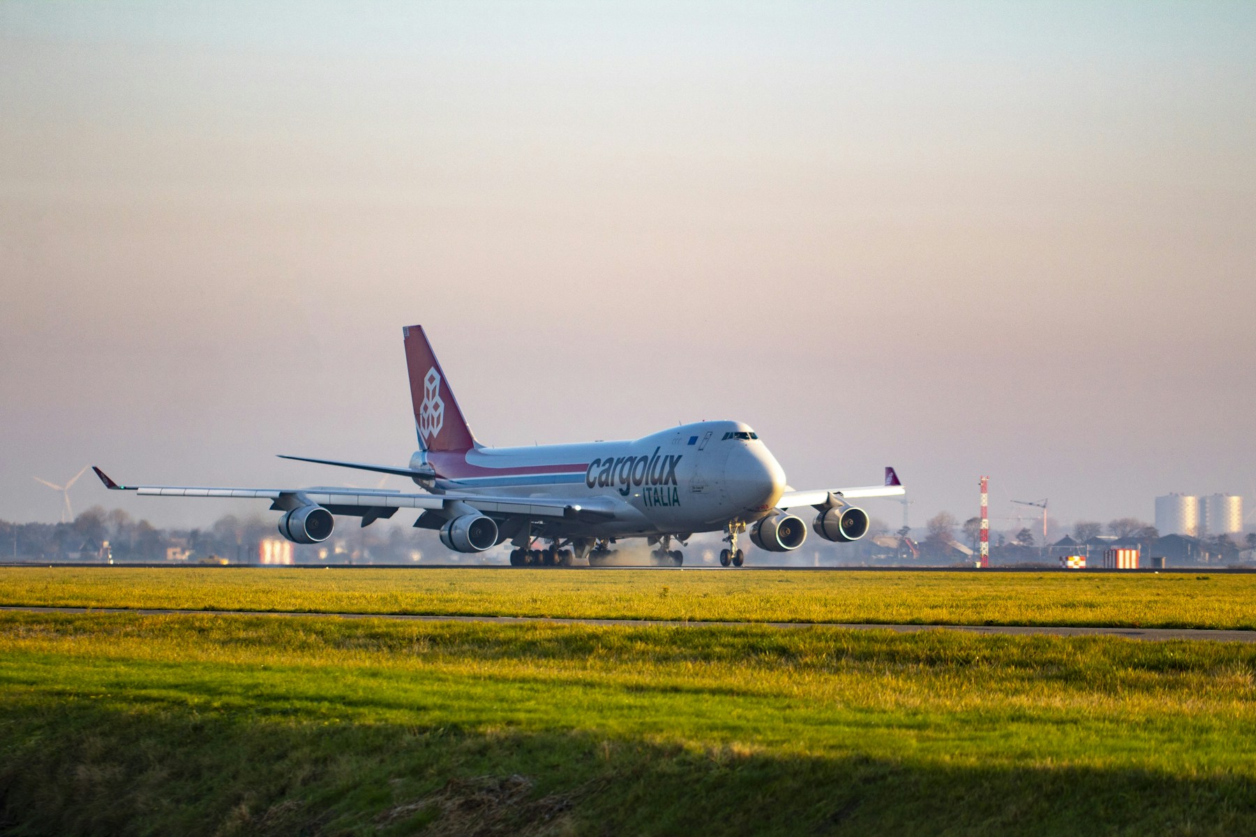 A Cargolux cargo aircraft on a runway at sunset