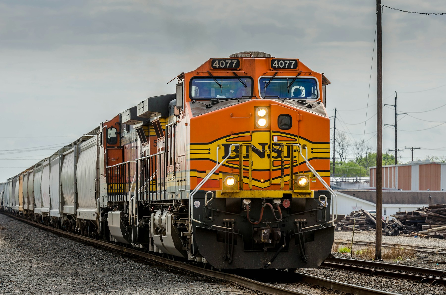 An orange BNSF locomotive pulling a freight train